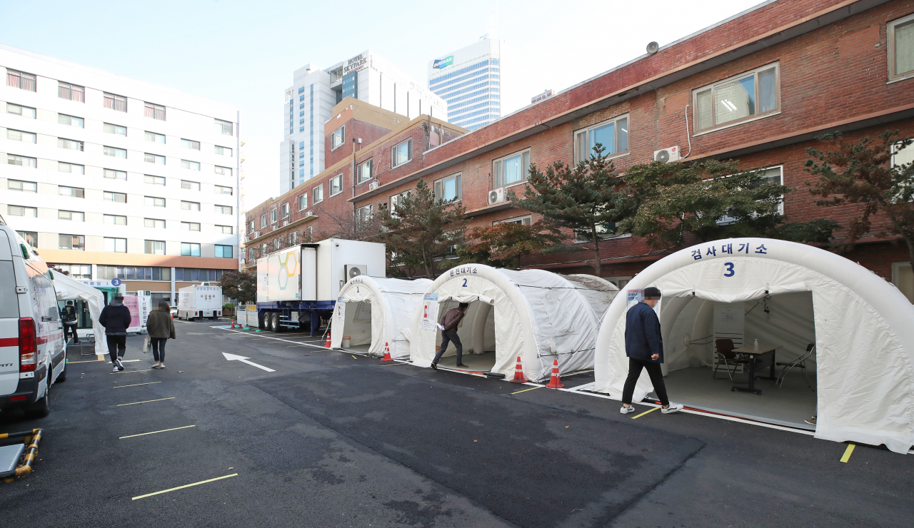 이틀째 코로나19 신규 확진자 수가 두 자릿수를 기록한 3일 오전 서울 중구 국립중앙의료원에 마련된 선별진료소를 찾은 시민들이 대기하고 있다. 이날 0시 기준 신규확진자 수는 75명으로 지역 발생이 46명, 해외유입이 29명이다. 하지만 최근 요양시설 및 병원을 비롯해 가족·지인 모임, 직장 등에서 집단 감염이 이어지고 있고 가을 단풍 여행과 핼러윈 데이 영향이 본격화되지 않아 언제든지 그 규모가 다시 증가할 수 있는 상황이다. [연합]