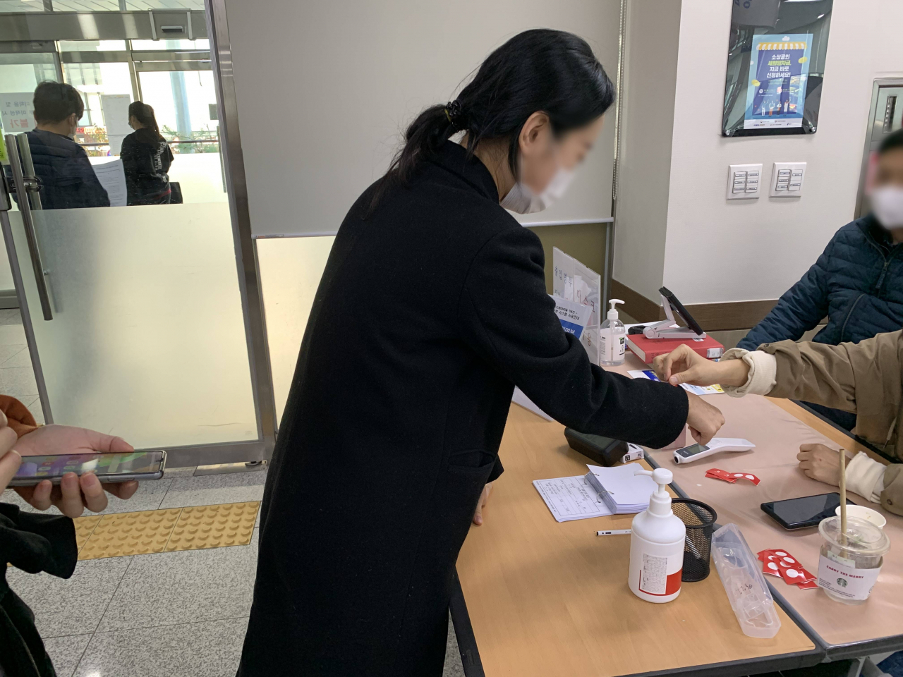 방문객에게 출입 인증 스티커를 부착하고 있다. [용인시 제공]