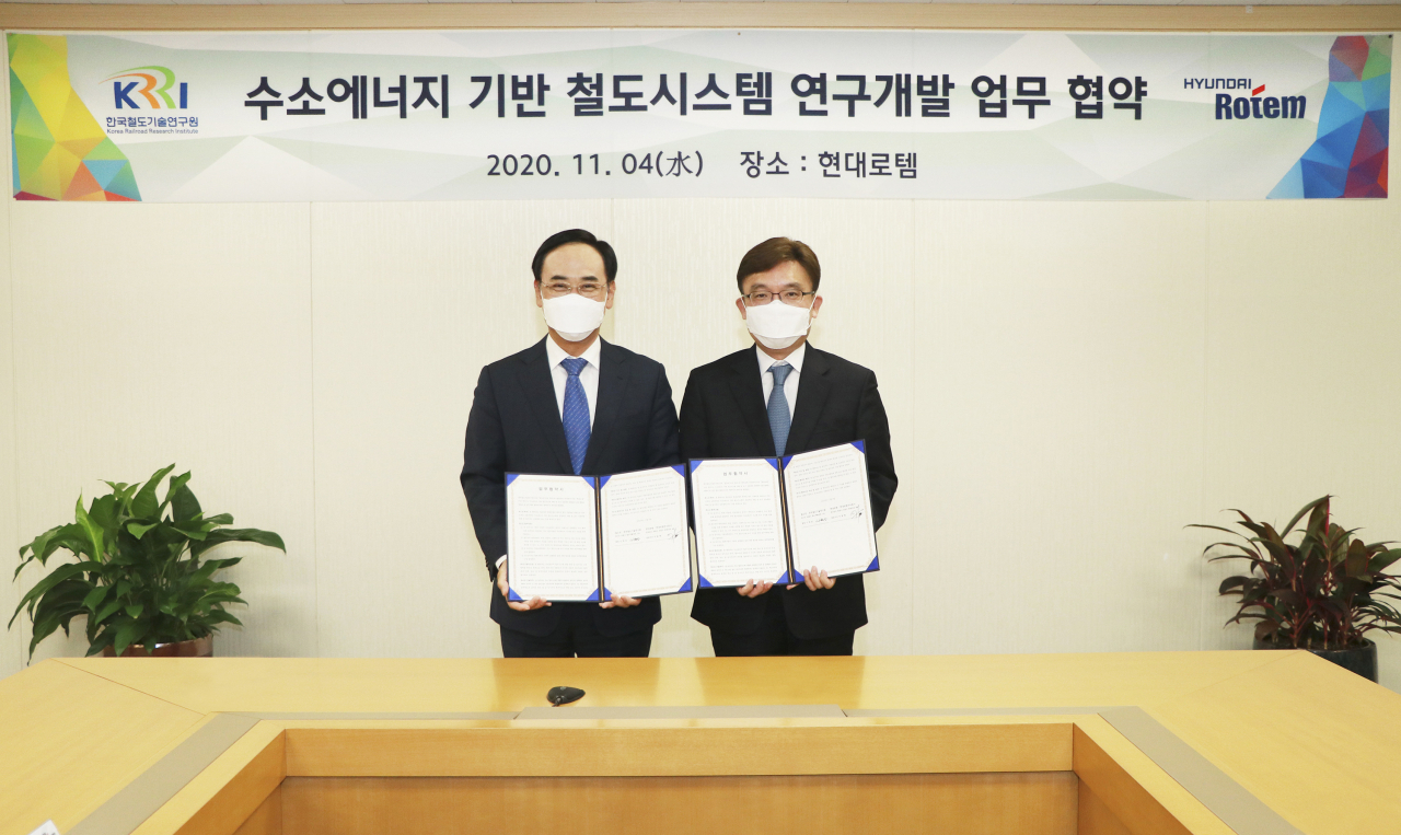 현대로템이 지난 4일 의왕 본사에서 한국철도기술연구원과 업무협약을 체결하고 수소전기열차 개발을 위한 기술교류에 나섰다. 이용배 현대로템 대표이사(사진 왼쪽)와 나희승 철도연 원장이 업무협약 체결 후 기념촬영을 하고 있다. [현대로템 제공]