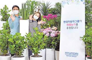 현대차그룹 정의선 회장이 코로나19로 어려움을 겪는 화훼농가를 응원하고자 ‘플라워 버킷 챌린지’에 동참했다. 현대차그룹 직원들이 ‘플라워 버킷 챌린지’를 응원하며 기념사진을 촬영하고 있다. [현대차 페이스북 자료]