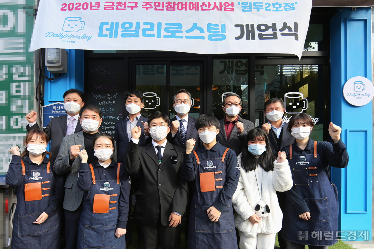 유성훈(뒷줄 왼쪽 세번째) 금천구청장을 비롯 데일리 로스팅 관계자들이 개업식 기념 화이팅을 하고 있다. [금천구 제공]