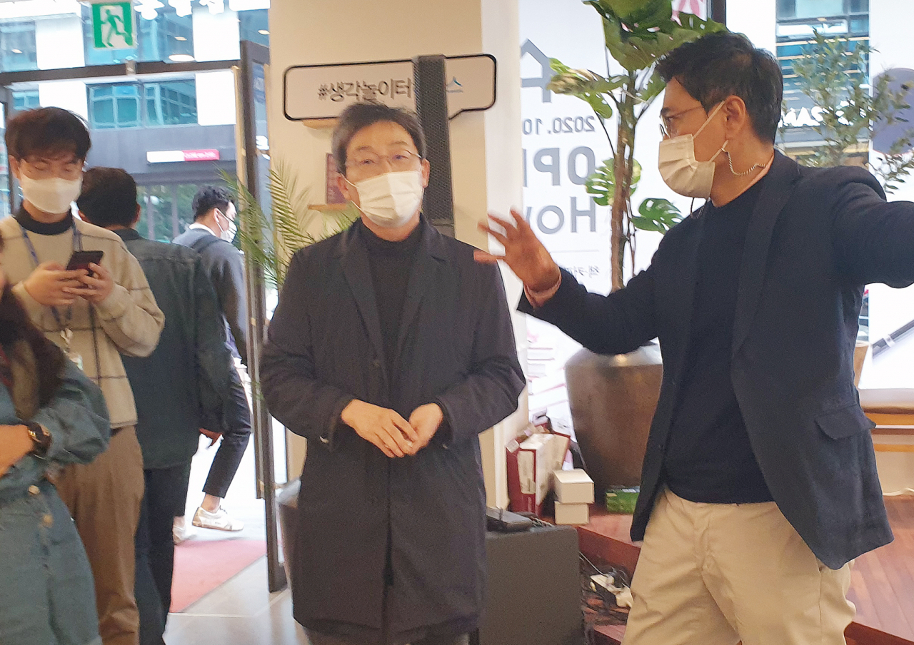 유승민 국민의힘 전 의원(가운데)이 21일 서울 여의도 정치문화플랫폼 하우스(How's)에서 열린 미디어 쇼케이스에서 오신환 이사장의 설명을 듣고 있다. [연합]