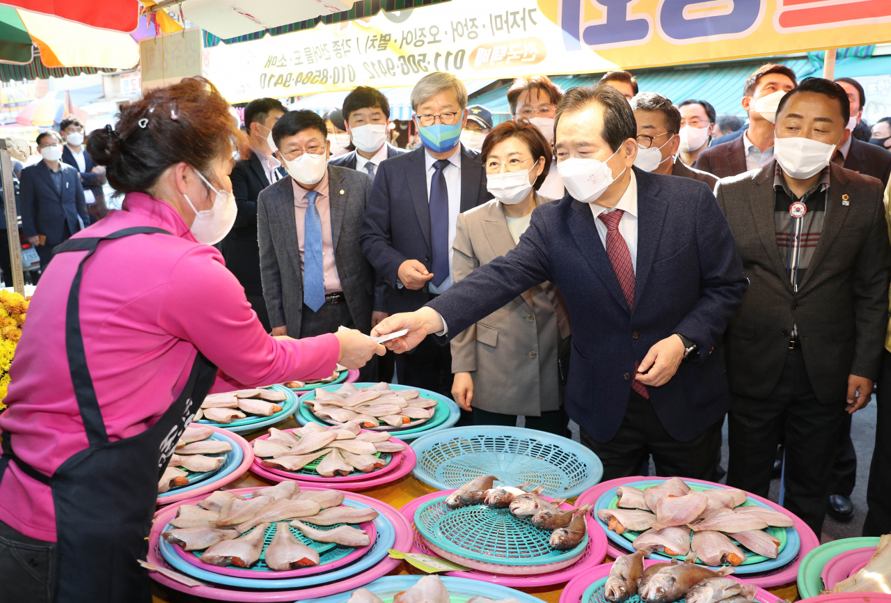 정세균 국무총리가 7일 경북 포항시 북구 죽도시장에서 지역 상품권으로 물건을 사고 있다. [사진=연합뉴스]
