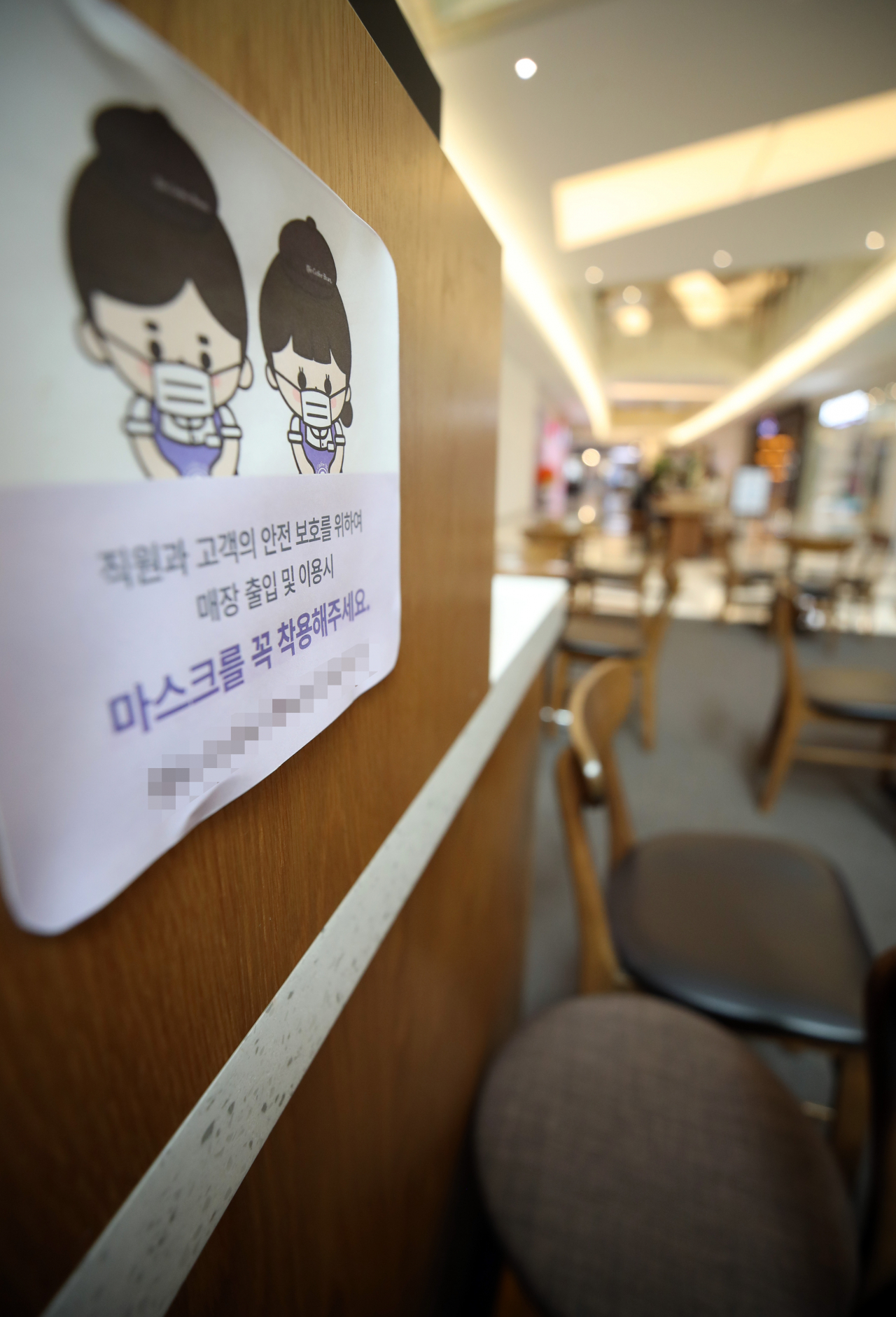 새로운 '사회적 거리두기' 1단계 시행 이틀째인 8일 서울의 한 쇼핑몰내 카페에 마스크 의무착용 관련 안내문이 설치되어 있다. 연합뉴스