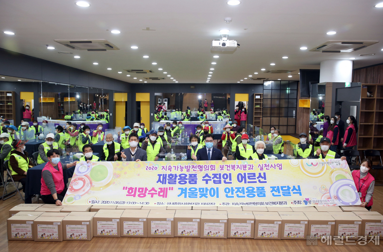 이정훈 강동구청장이 성내종합사회복지관에서 재활용품 수집 어르신 30명을 대상으로 ‘희망수레’ 사업인 겨울맞이 안전용품을 전달하고 기념사진을 찍고 있다. [강동구 제공]
