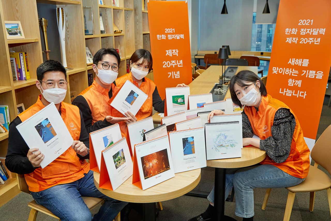 한화 점자달력 제작 20주년을 맞아 한화봉사단 임직원들이 2001년 점자달력부터 시작해 지난 20년간 제작된 한화 점자달력을 소개하며 기념촬영 하고 있다. [한화그룹 제공]