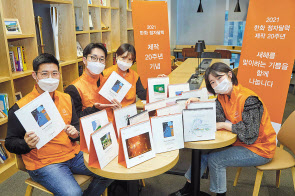 한화 점자달력 제작 20주년을 맞아 한화봉사단 임직원들이 2001년 점자달력부터 시작해 지난 20년간 제작된 한화 점자달력을 소개하며 기념촬영 하고 있다. [한화그룹 제공]