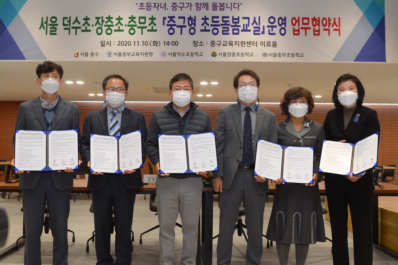 10일 열린 업무협약식서 서양호 구청장(왼쪽에서 세번째), 조희연 서울교육감(왼쪽에서 네번째) 등 주요 참석자들이 서명된 협약서를 들어보이고 있다. [중구 제공]