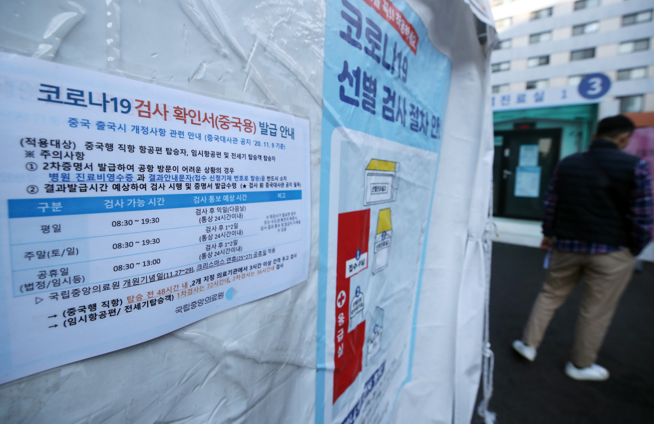 한국에서 출발하는 항공편을 통해 중국에 들어가는 사람들에 대한 코로나19 유전자증폭(PCR) 진단검사 음성확인서 2장 제출이 의무화된 첫날인 11일 서울 중구 국립중앙의료원 선별진료소에 관련 안내문이 붙어 있다. 연합뉴스