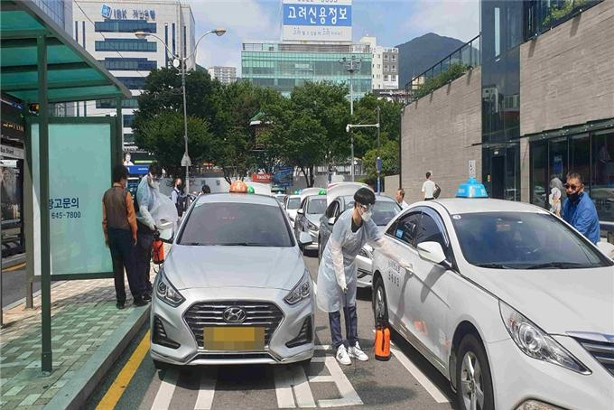 부산역에서 운영 중인 택시방역소에서 택시를 소독하고 있다. [부산시 제공]