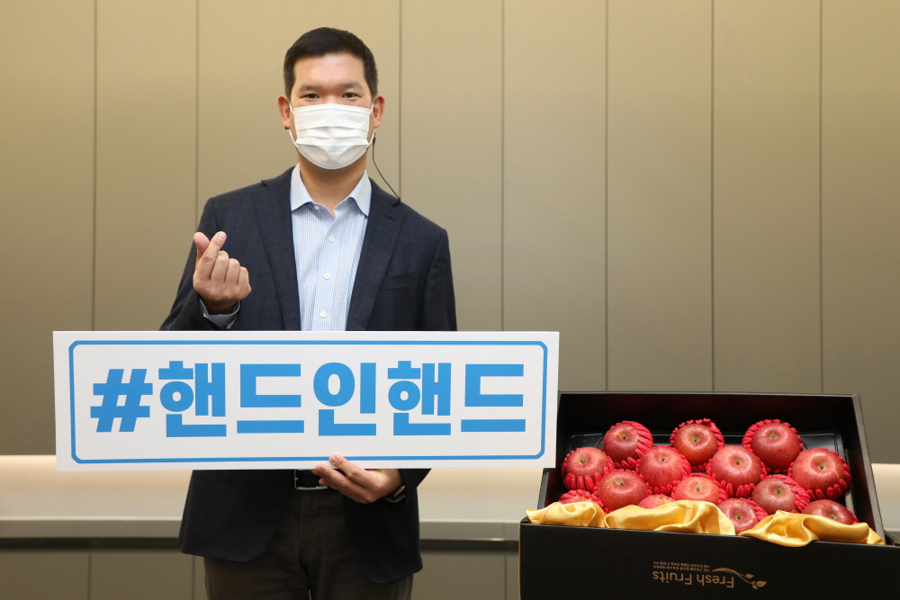 허윤홍 GS건설 신사업부문 대표가 11일 서울 그랑서울 본사에서 코로나19로 어려움을 겪는 사회적경제기업을 돕기 위한 ‘핸드온핸드’ 소셜 릴레이 캠페인에 동참해 포즈를 취하고 있다. 허 대표는 영농조합법인에서 구매한 사과를 ‘꿈과 희망의 공부방’가정과 아동들에 전달했다. [GS건설]