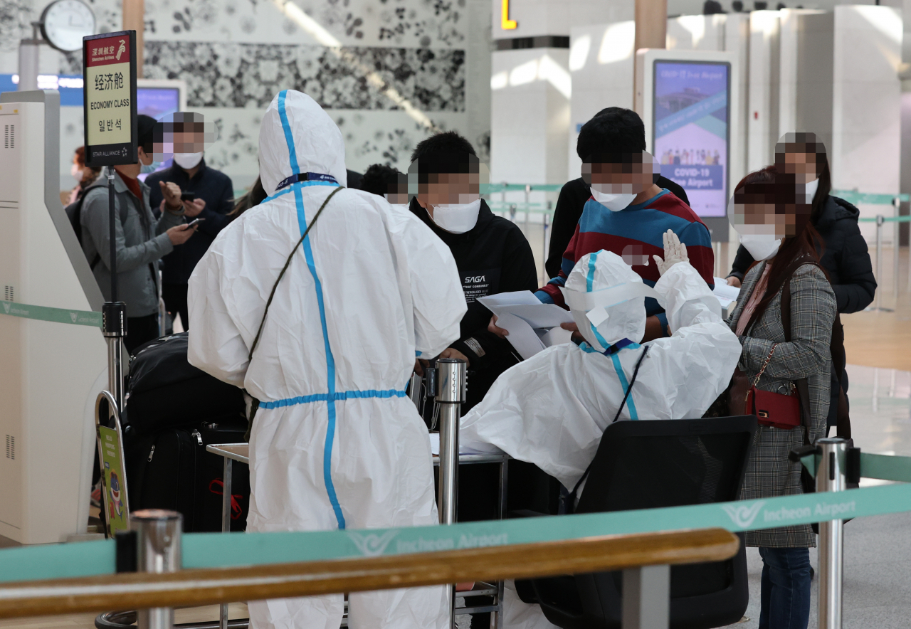 11일 오후 인천국제공항 1터미널 출국장 중국 선전행 항공기 체크인카운터에서 승객들이 신종 코로나바이러스 감염증(코로나19)에 걸리지 않았다는 것을 증명하는 음성확인서를 준비하고 있다. 연합뉴스