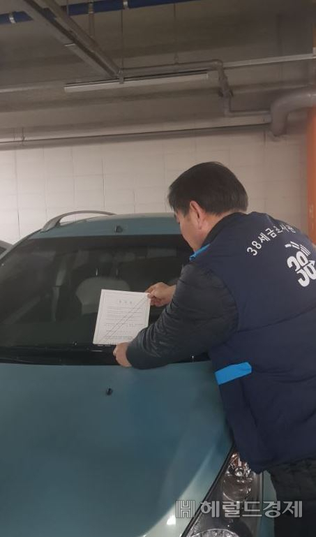 세금 체납자 차량에 압류 통지를 붙이고 있는 모습. [마포구 제공]