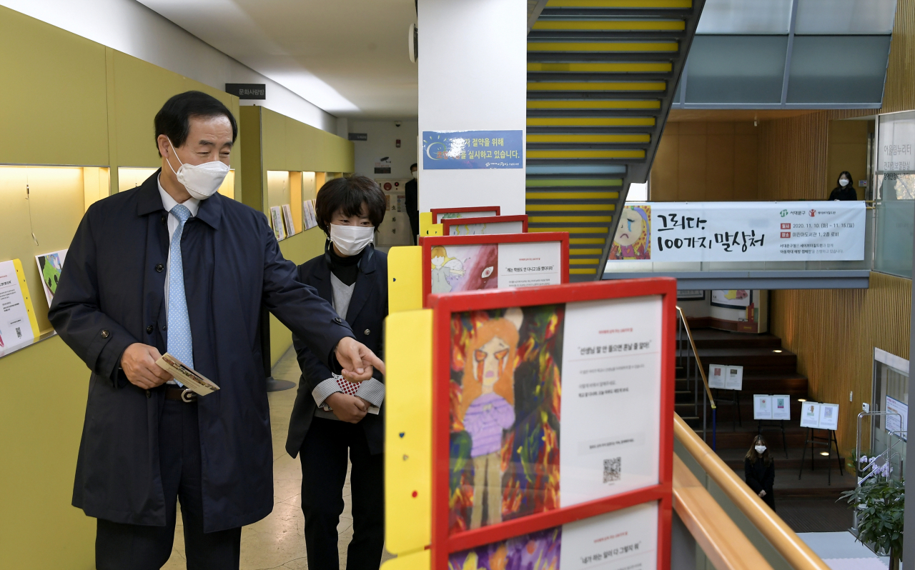 지난 12일 문석진 서대문구청장이 이진아기념도서관을 찾아 ‘그리다 100가지 말상처’ 기획전 전시물들을 관람하고 있다. [서대문구 제공]