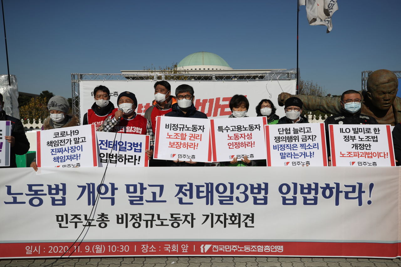 Members of the Korean Confederation of Trade Unions call on lawmakers to legislate labor rights protections during a press conference held in front of the National Assembly building in Yeouido, central Seoul. (Yonhap)