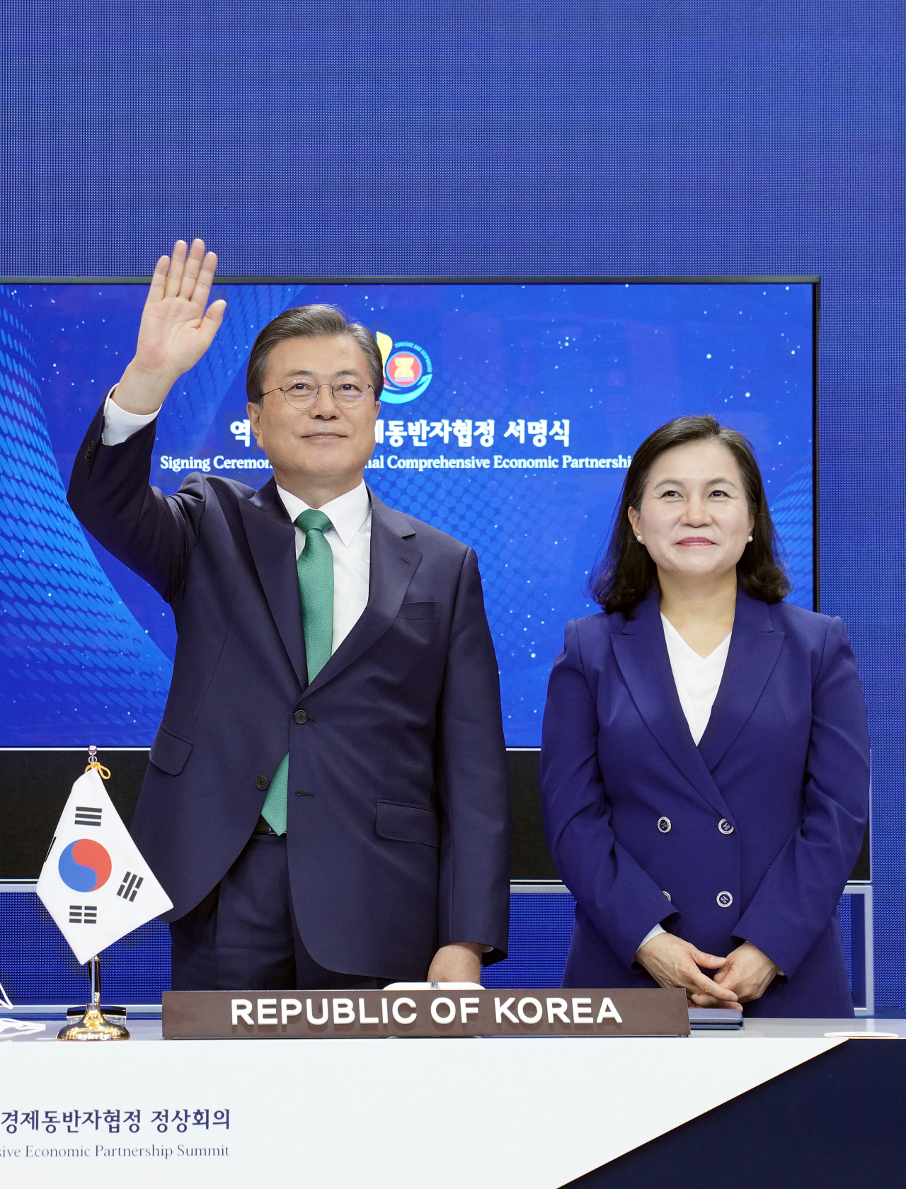 문재인 대통령이 15일 청와대에서 열린 세계 최대규모의 자유무역협정(FTA)인 '역내포괄적경제동반자협정(RCEP)' 협정문 서명식에 참석, 서명을 마친 유명희 통상교섭본부장과 함께 서서 참여국 정상들을 향해 손을 흔들고 있다. [연합]