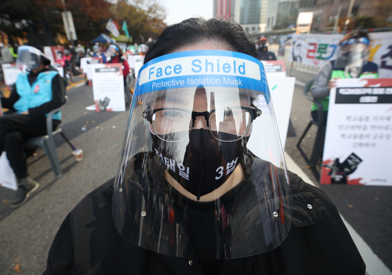 토요일이었던 지난 14일 오후 서울 영등포구 여의도공원 앞에서 열린 전국노동자대회. 한 집회 참가자가 페이스 실드를 착용하고 있다. [연합]