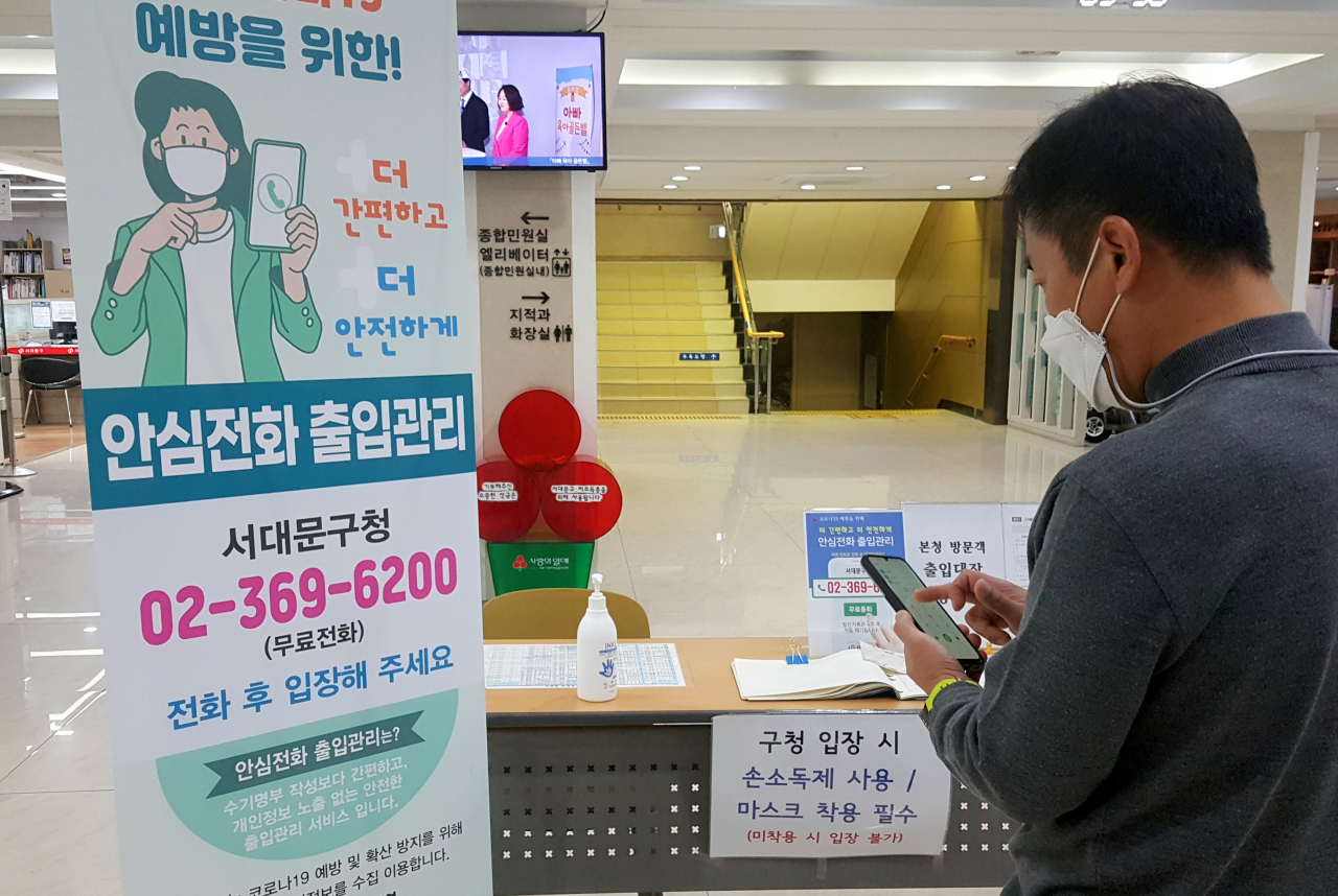 서대문구가 관내 33개 시설에서 ‘전화통화 방식의 방문자 출입기록 서비스’를 시작했다. 사진은 서대문구청 입구에서 안내돼 있는 연락처로 전화를 걸고 있는 방문자 모습. [서대문구 제공]
