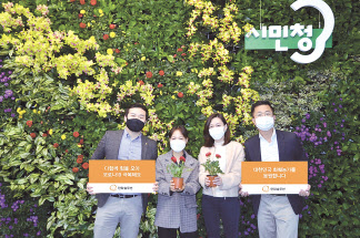 플라워 아트월 앞에서 사진을 찍고 있는 한화솔루션 직원들. [한화솔루션 제공]
