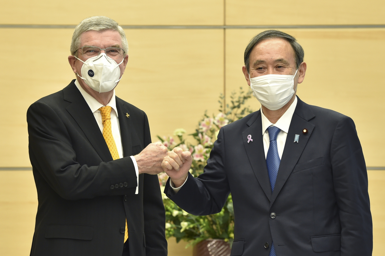 스가 요시히데(菅義偉·오른쪽) 일본 총리와 토마스 바흐 국제올림픽위원회(IOC) 위원장은 16일 도쿄 총리관저에서 회담을 갖고 기자들 앞에서 주먹인사를 나누고 있다. [EPA]