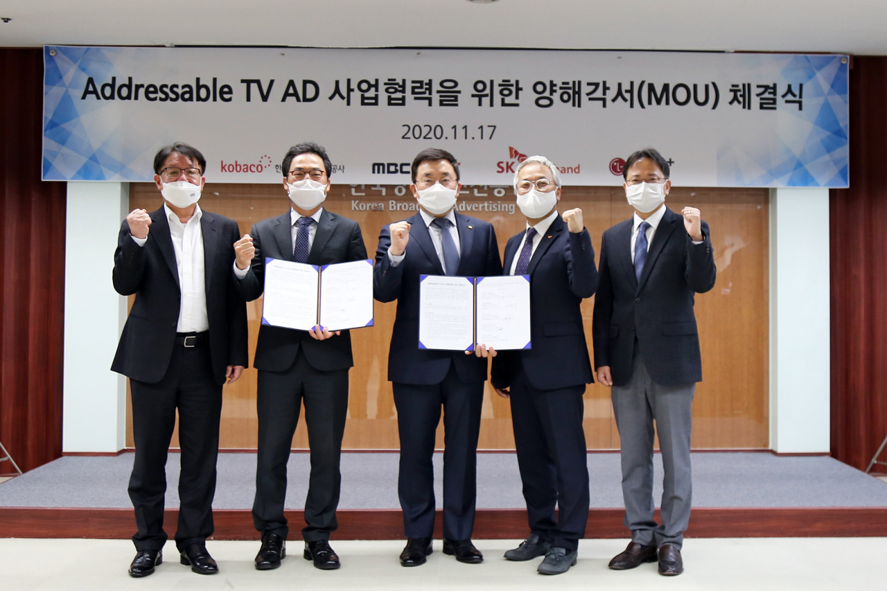 지난 17일 오후 서울 광화문 코바코에서 진행된 ‘어드레서블(Addressable) TV 광고 사업협력을 위한 양해각서(MOU)’ 협약식에서 (왼쪽부터) 코바코 서명석 혁신성장본부장, MBC 이근행 콘텐츠전략본부장, KT 송재호 미디어플랫폼사업본부장, SK브로드밴드 김혁 미디어전략본부장, LG유플러스 최창국 Consumer 사업그룹장이 기념사진을 찍고 있다. [코바코, SK브로드밴드 제공]