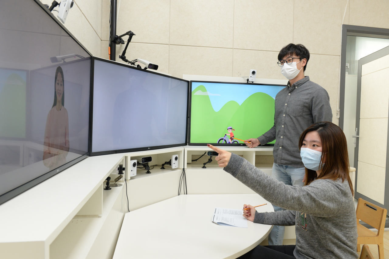 ETRI 연구진이 자폐스펙트럼장애 선별을 위해 개발 중인 ‘영유아의 사회적 상호작용 유도 콘텐츠’를 시연하고 있다.[ETRI 제공]