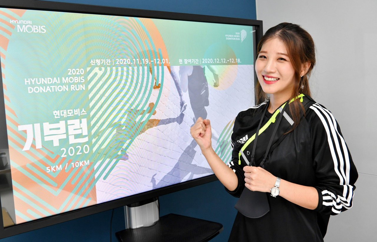 현대모비스가 오는 12월 개최하는 신개념 언택트 마라톤 행사의 참가 신청을 오늘부터 받는 가운데, 마라톤에 참여하는 직원이 언택트 기부런에서 제공하는 기념품을 착용하고 포즈를 취하고 있다. [현대모비스 제공]
