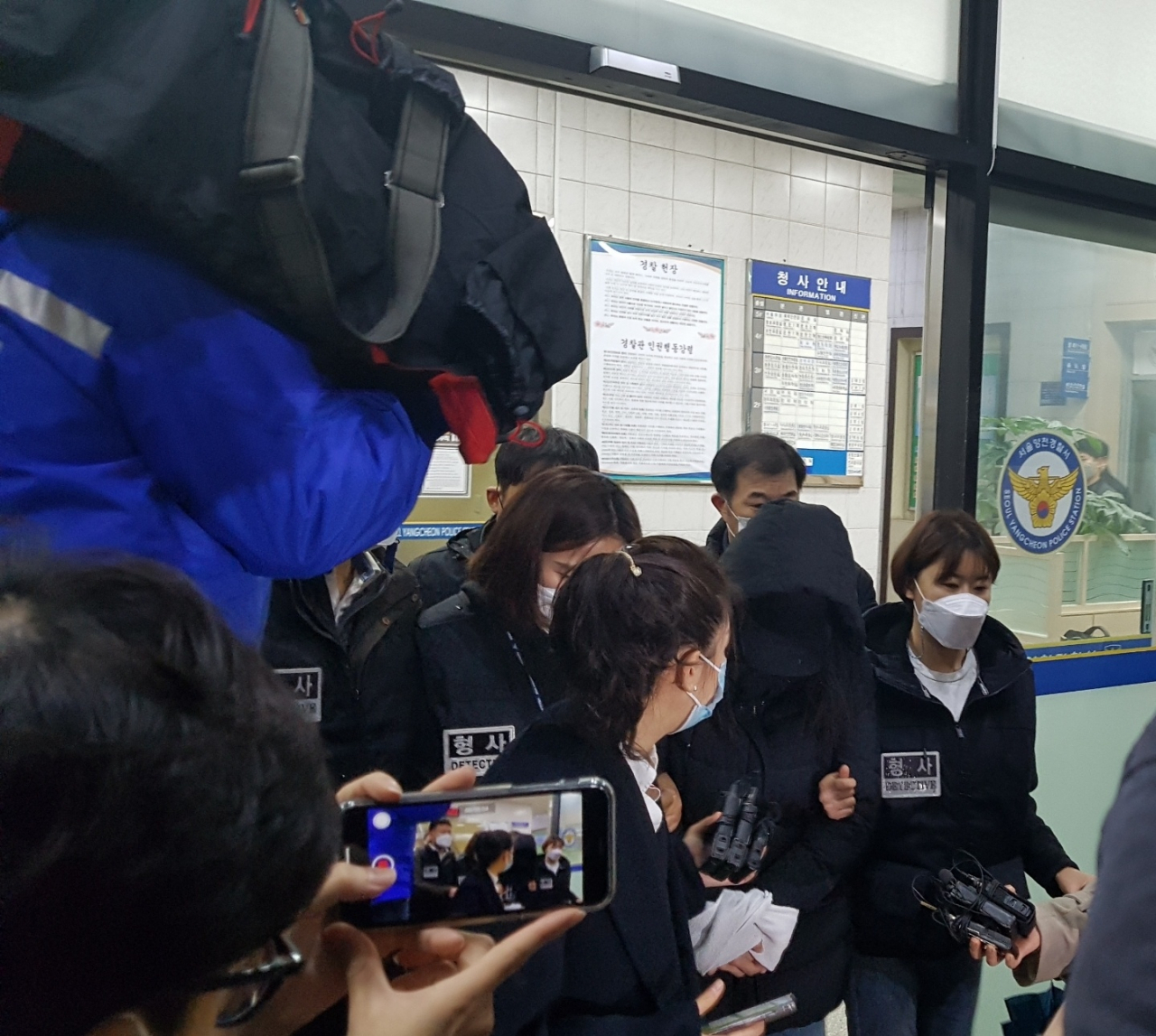 16개월 영아 학대치사 혐의를 받고 있는 A(가운데 검정 후드 재킷 착용한 사람)씨가 19일 검찰 송치를 위해 서울 양천경찰서를 나서고 있다. 윤호 기자/youknow@heraldcorp.com