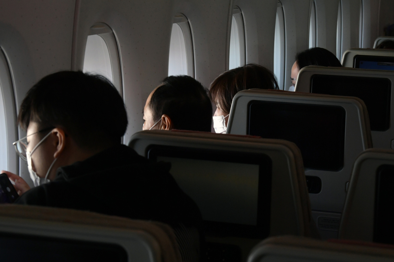 Passengers stare outside the windows in a sightseeing program offered by Asiana Airlines, in this photo taken on Oct. 24. (Yonhap)