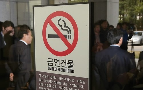 2014년 대법원 '담배소송' 확정 판결 직후 기자회견을 하는 피해자 유족과 변호사 모습이 건물 유리에 비치는 장면. [연합]