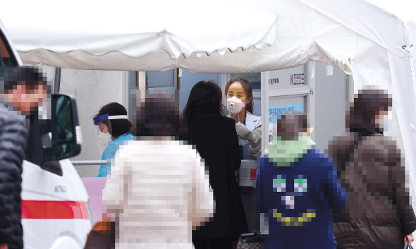 20일 서울 중구 국립중앙의료원 신종 코로나바이러스 감염증(코로나19) 선별진료소에서 의료진이 검체 채취를 하고 있다. 중앙방역대책본부는 이날 0시 기준으로 코로나19 신규 확진자가 363명 늘어 누적 3만17명이라고 밝혔다. 신규 확진자 363명은 수도권의 2차 유행이 정점을 찍은 직후였던 8월 28일(371명) 이후 84일 만에 최다 기록이다. [연합]