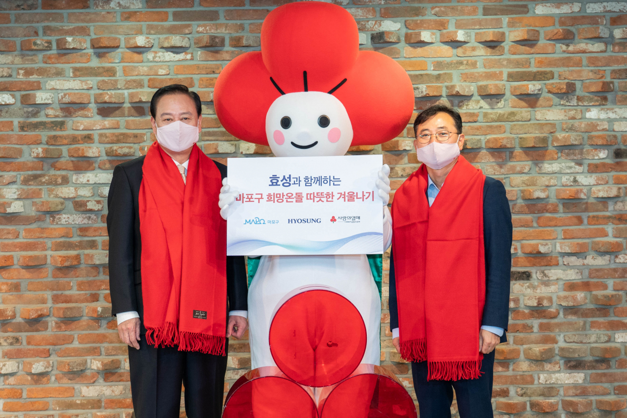 유동균 서울 마포구청장(왼쪽)과 효성 커뮤니케이션실 최형식 상무가 성금 전달식을 갖고 기념촬영을 하고 있다. [효성 제공]