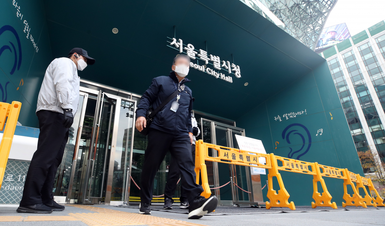 20일 오후 신종 코로나바이러스 감염증(코로나19) 확진자가 발생해 폐쇄된 서울시청 본관에서 직원들이 귀가하고 있다. 연합뉴스