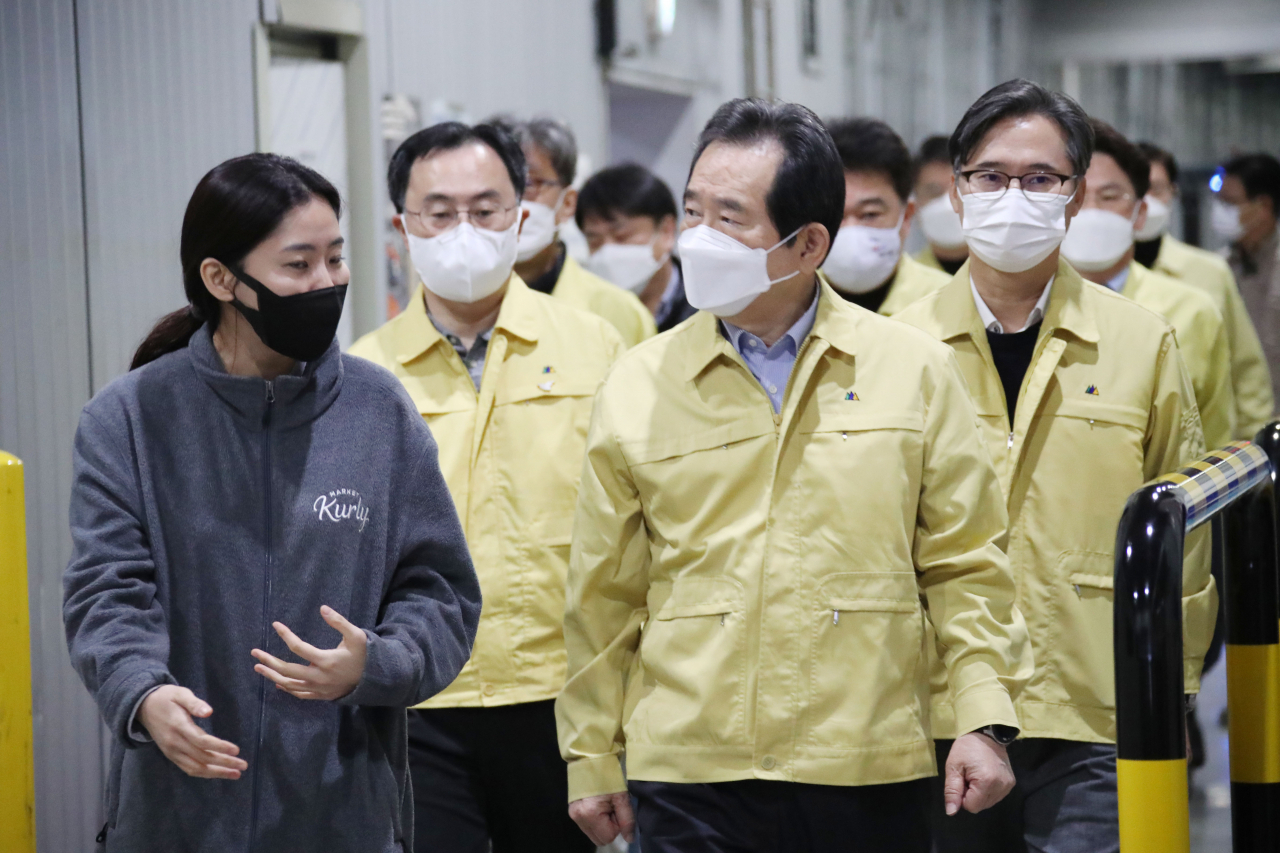 정세균 국무총리가 21일 코로나바이러스 감염증(코로나19) 방역현장 점검차 서울 송파구 마켓컬리 장지물류센터를 방문해 김슬아 대표(왼쪽)로부터 설명을 들으며 방역현장을 둘러보고 있다. 연합뉴스