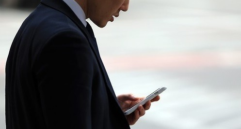 한 남성이 길에서 스마트폰을 사용하고 있다. [연합]