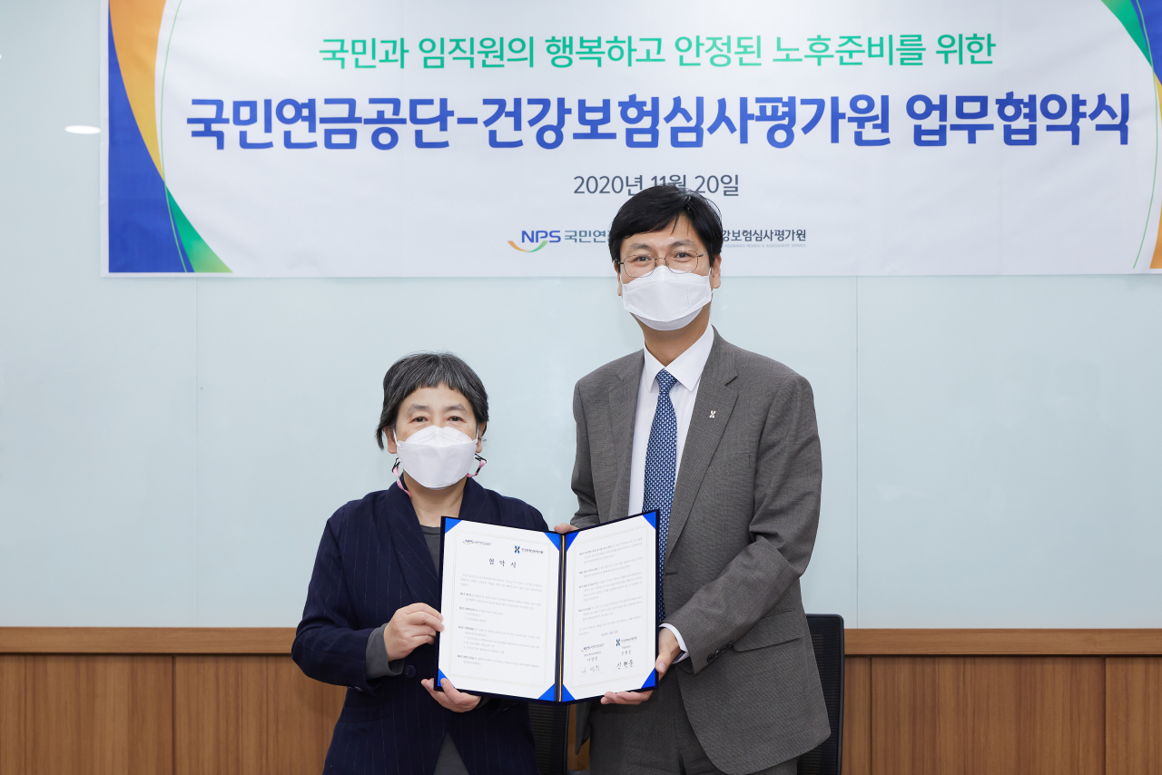 국민연금공단 서울남부지역본부에서 지난 20일 열린 업무협약식에서 공단 나영희 중앙노후준비지원센터장(왼쪽)과 건강보험심사평가원 신현웅 기획상임이사(오른쪽)가 협약 체결 후 기념 촬영을 하고 있다. [국민연금공단 제공]
