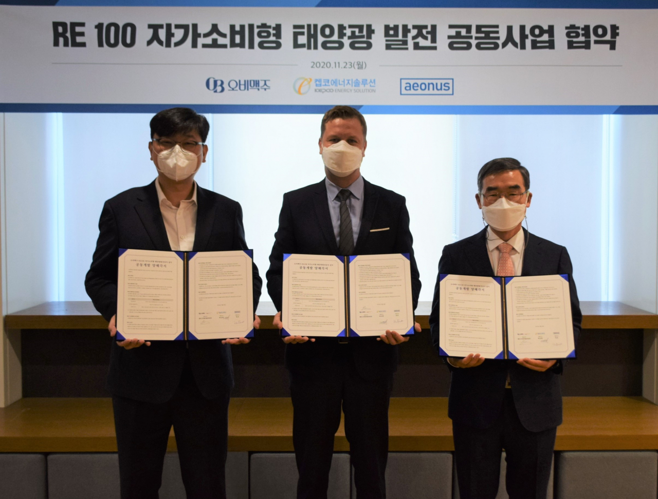 배하준 오비맥주 대표(가운데)가 배성환 켑코에너지솔루션 대표(오른쪽), 허은 이온어스 대표(왼쪽)와 함께 태양광 발전 공동사업 협약을 체결하고 단체 사진을 찍고 있다. [제공=오비맥주]