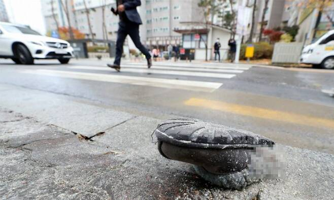 17일 오전 광주 북구 운암동의 한 아파트 단지 인근 횡단보도에서 50대 남성이 몰던 트럭이 일가족을 치어 2살 어린아이가 숨지는 등 3명의 사상자가 났다. 사고 현장에 피해자의 것으로 추정된 신발이 놓여 있다[연힙]