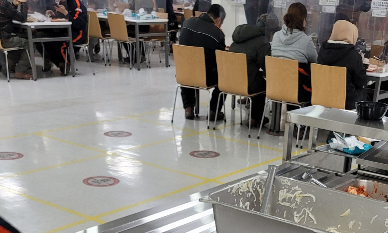 경기 부천에 위치한 쿠팡 부천신선센터 내부 식당의 모습. 한 칸 띄어앉거나 맞은 편을 비워두지 않은 채 투명 가림판을 사이에 두고 직원들이 식사를 하고 있다. [쿠팡 부천신선센터 직원 A씨 제공]
