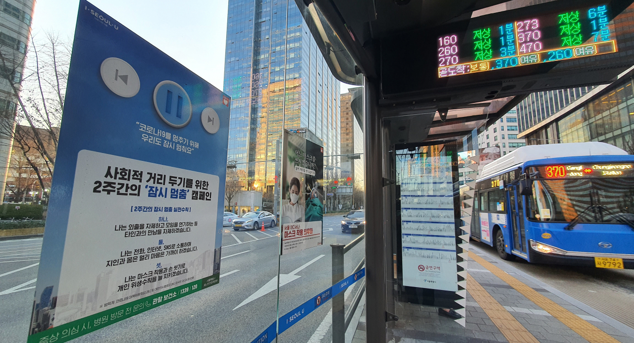 23일 서울 시내 버스정류장에 코로나19 방역 안내문이 붙어 있다. 서울시는 이날 '1천만 시민 긴급 멈춤기간'을 선포했다. 24일부터 연말까지 대중교통 야간 운행을 감축하고 10명 이상의 집회를 전면 금지한다. 연합뉴스