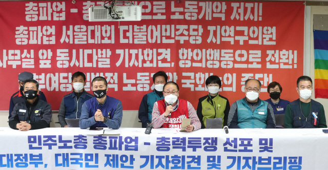 민주노총 조합원들이 24일 서울 중구 민주노총 교육장에서 기자회견을 열고 25일 총파업을 열기로 했다. [연합]