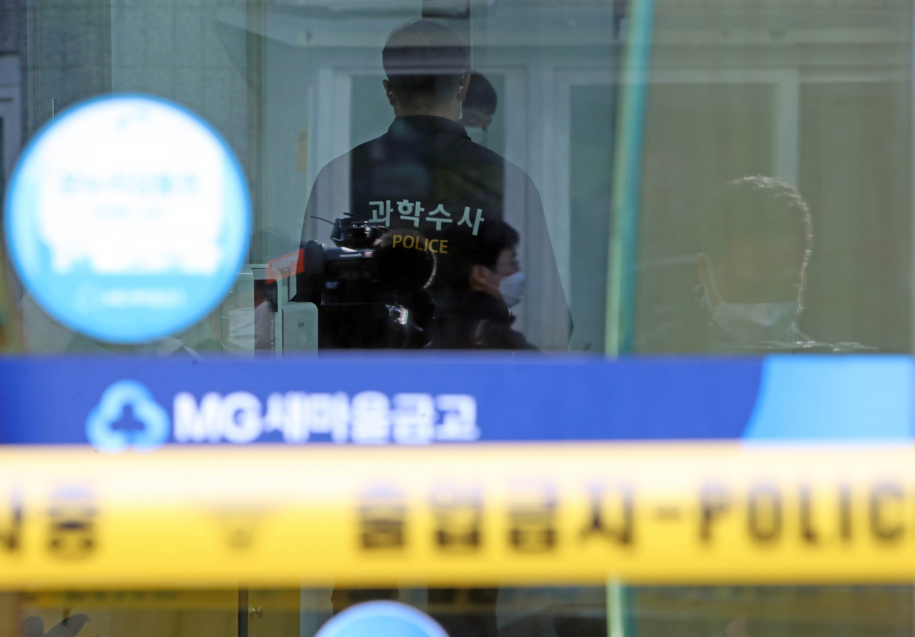 24일 오후 대구 동구 한 새마을금고에서 경찰들이 현장 조사를 하고 있다. 이날 오전 이곳에서는 60대 남성이 흉기를 휘둘러 직원 2명이 숨졌다. [연합]