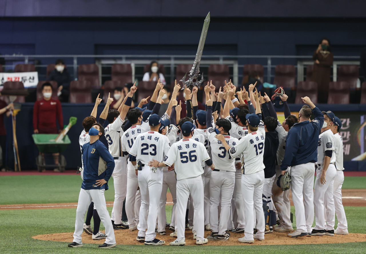24일 고척스카이돔에서 열린 2020 프로야구 한국시리즈(KS) 6차전 두산 베어스와 NC 다이노스의 경기에서 선수들이 그라운드에서 모기업 NC소프트의 온라인게임 리니지의 집행검을 들어올리며 승리를 자축하고 있다. NC는 창단 9년 만에 통합 우승을 차지했다. [연합]