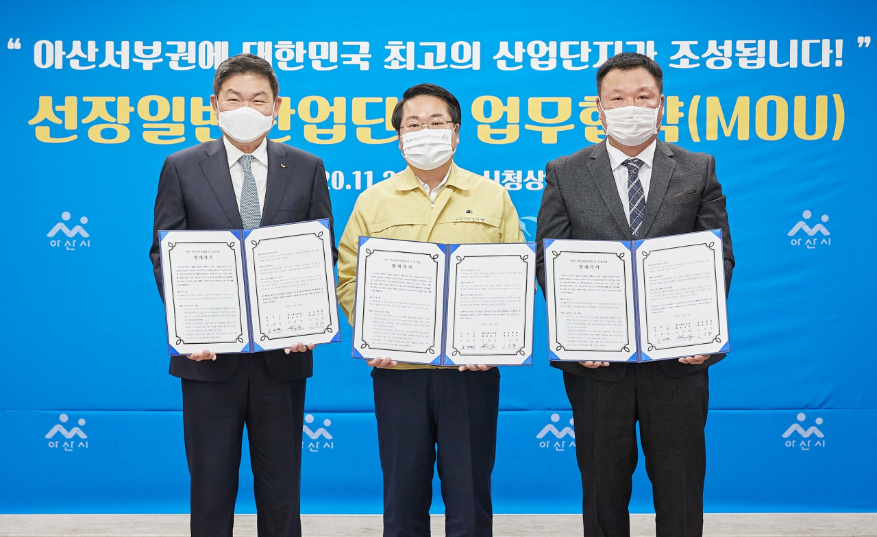안재현 SK건설 사장(왼쪽부터), 오세현 아산시장, 고성한 완성개발 대표이사가 협약서를 들고 기념촬영을 하고 있다.[SK건설 제공]
