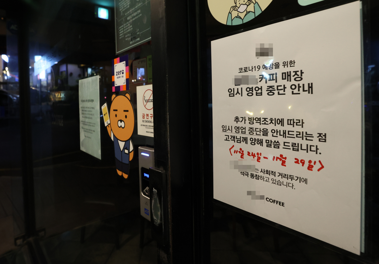 신종 코로나바이러스 감염증(코로나19) 확산으로 서울 등 수도권에 사회적 거리두기 2단계가 시행된 24일 오후 서울 서초구 신사역 인근 커피전문점 입구에 임시 영업 중단 안내문이 부착돼 있다. 연합뉴스
