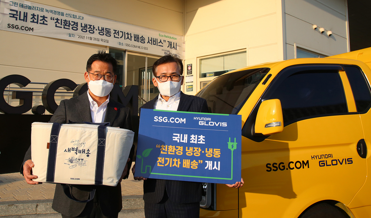 현대글로비스가 SSG닷컴 신선상품 배송차량으로 1t 전기트럭 1대를 시범 투입한다. 김진곤 현대글로비스 신성장물류사업부장(오른쪽)과 곽정우 SSG닷컴 운영본부장이 국내 최초 친환경 콜드체인 전기차 운행에 앞서 기념촬영을 하고 있다. [현대글로비스 제공]