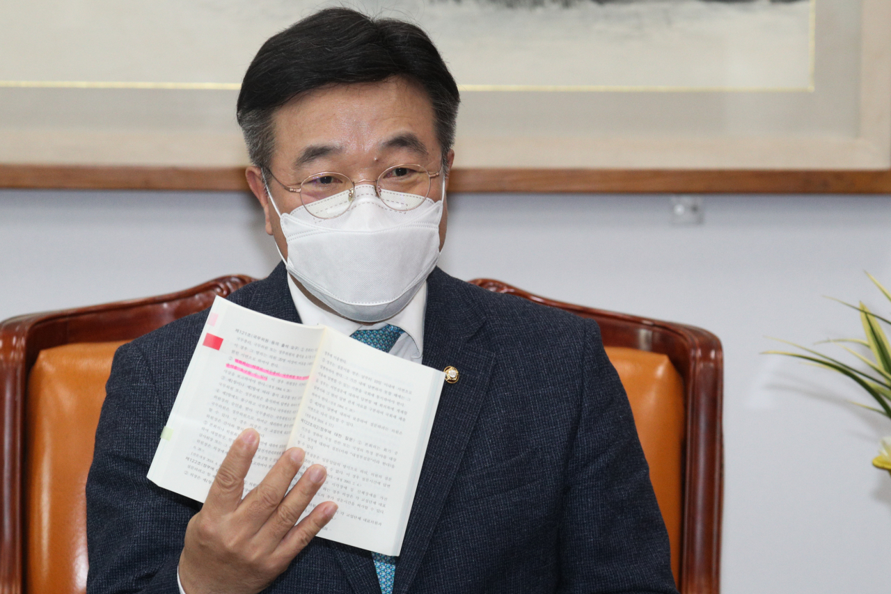 윤호중 국회 법제사법위원장이 26일 국회에서 국민의힘 법사위원들의 항의방문을 받은 뒤 가진 긴급 기자 간담회에서 '헌법·국회관계법'을 보여주며 설명하고 있다. [연합]