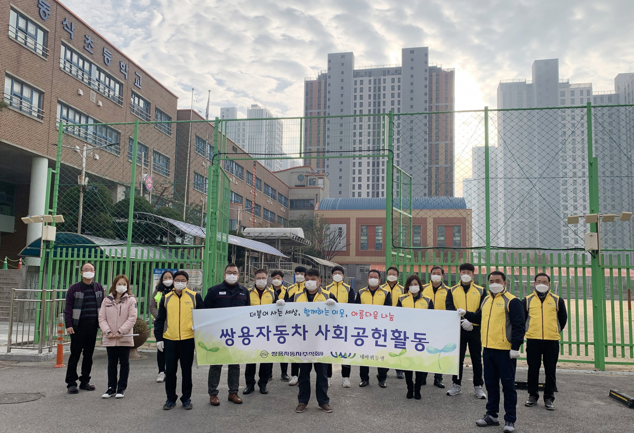 쌍용차 임직원들이 평택 동삭초등학교에서 교통안전 캠페인을 진행한 뒤 기념촬영을 하고 있다. [쌍용차 제공]