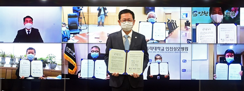박남춘 인천광역시장이 27일 접견실에서 열린 '1회용품 없는 장례문화 조성을 위한 비대면 업무협약식'에서 서명한 협약서를 들고 기념촬영을 하고 있다.
