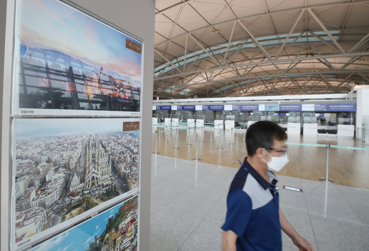 인천국제공항 제1 여객터미널 출국장 여행사 카운터 앞으로 공항 직원이 지나고 있다. [연합]